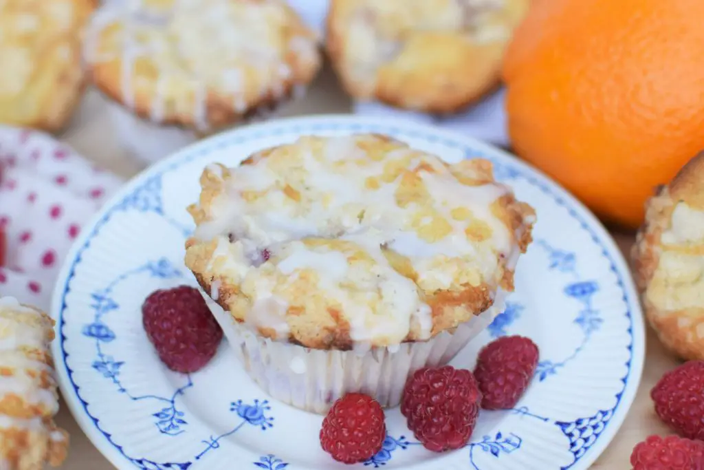 raspberry muffin with crumb topping sitting on a plate - this bread will rise