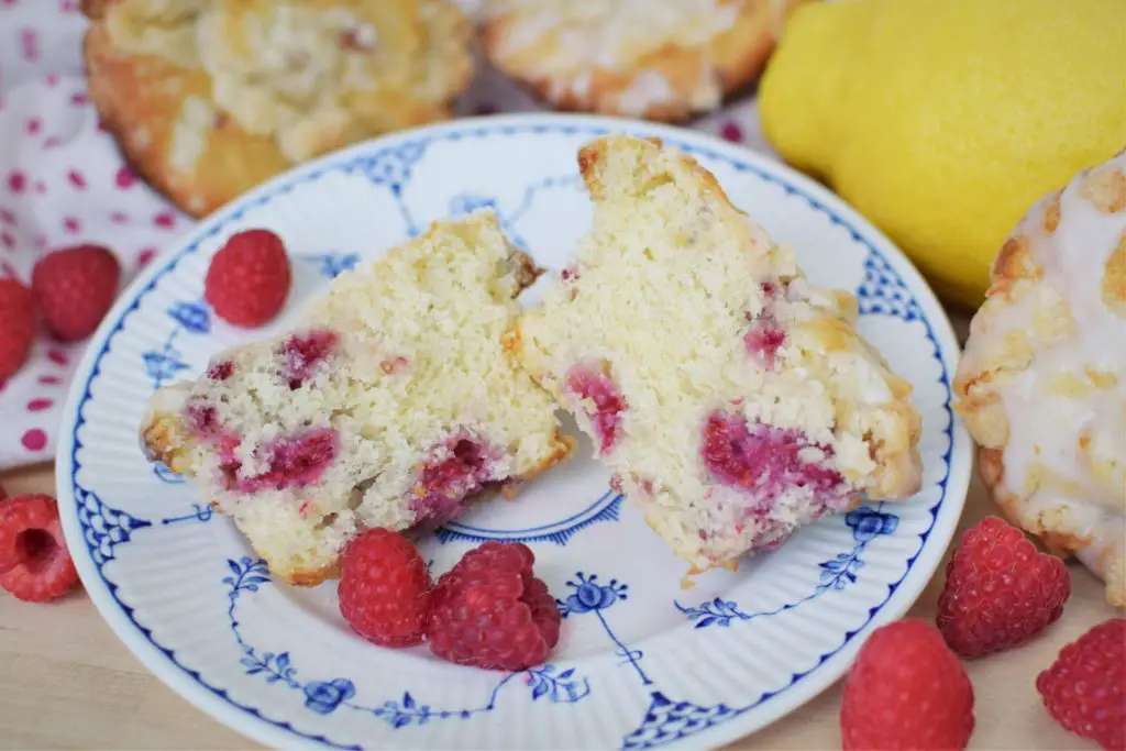 Cut open raspberry crumb muffin on a plate - this bread will rise