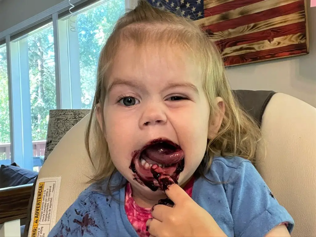 Ellie making a silly face with blueberry puree