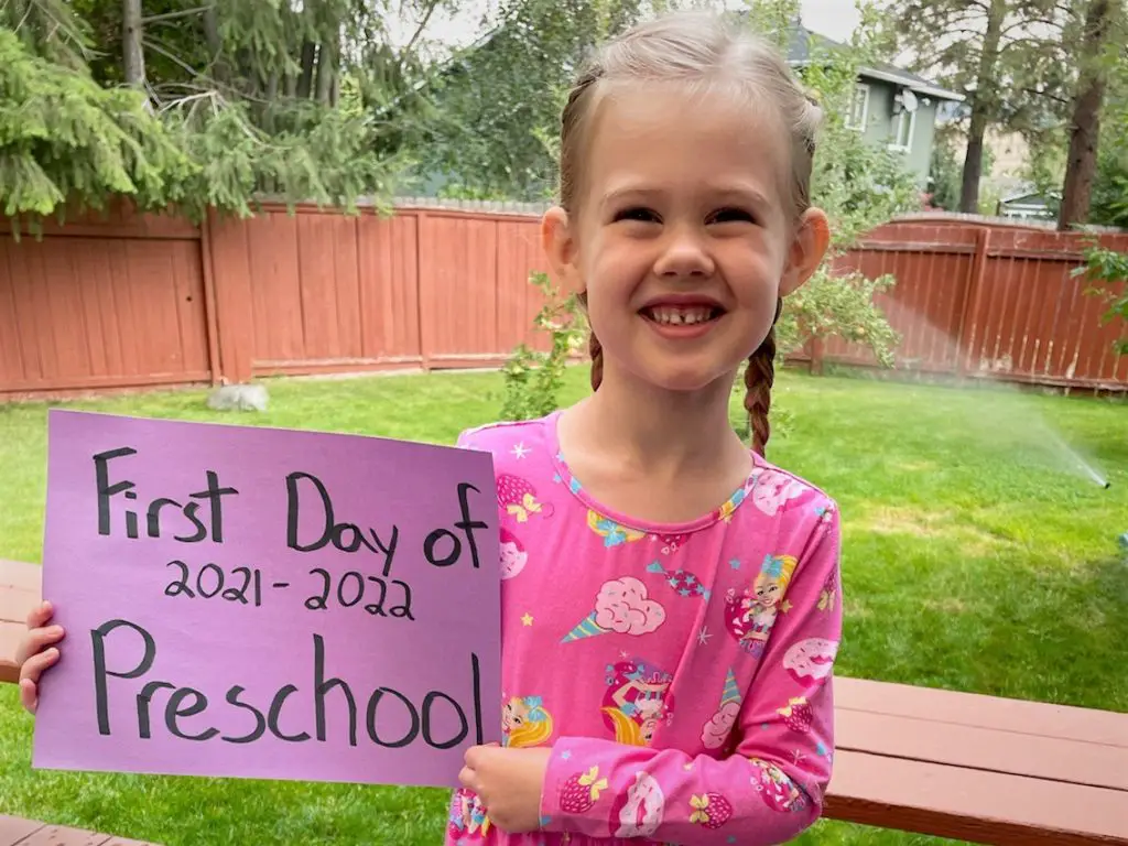 Rosie holding a first day of preschool sign