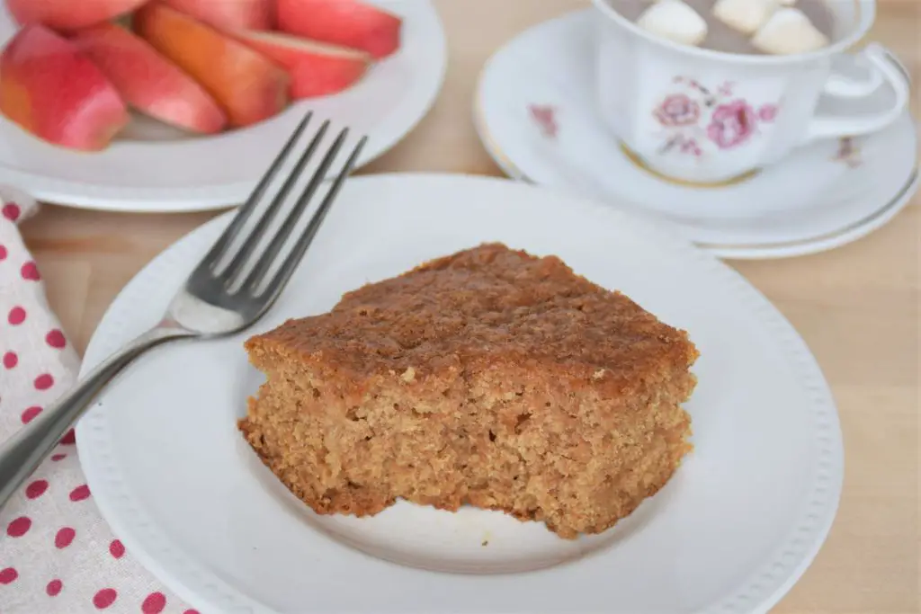 Served cinnamon applesauce snack cake with bite out and pretty tea cup