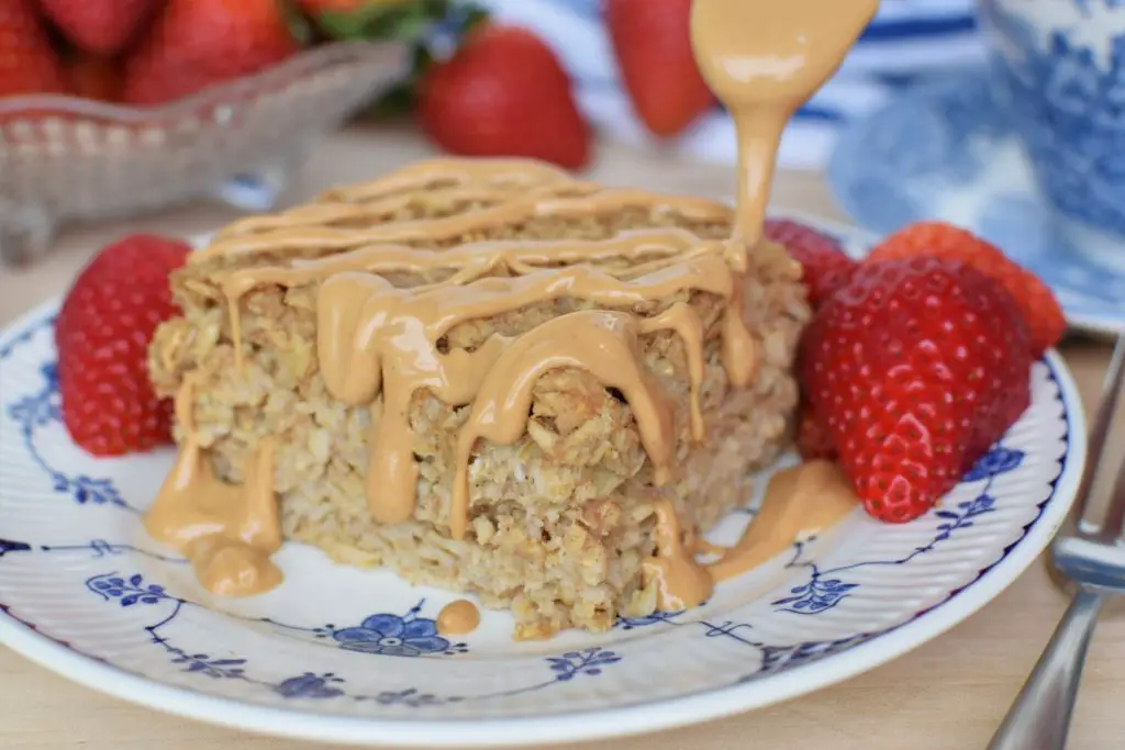 Baked Oatmeal with cashew butter being drizzles across the top
