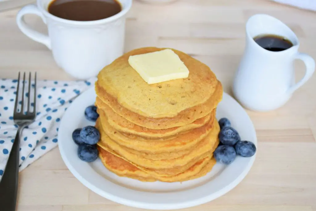 stack of butternut squash pancakes with butter and blueberries