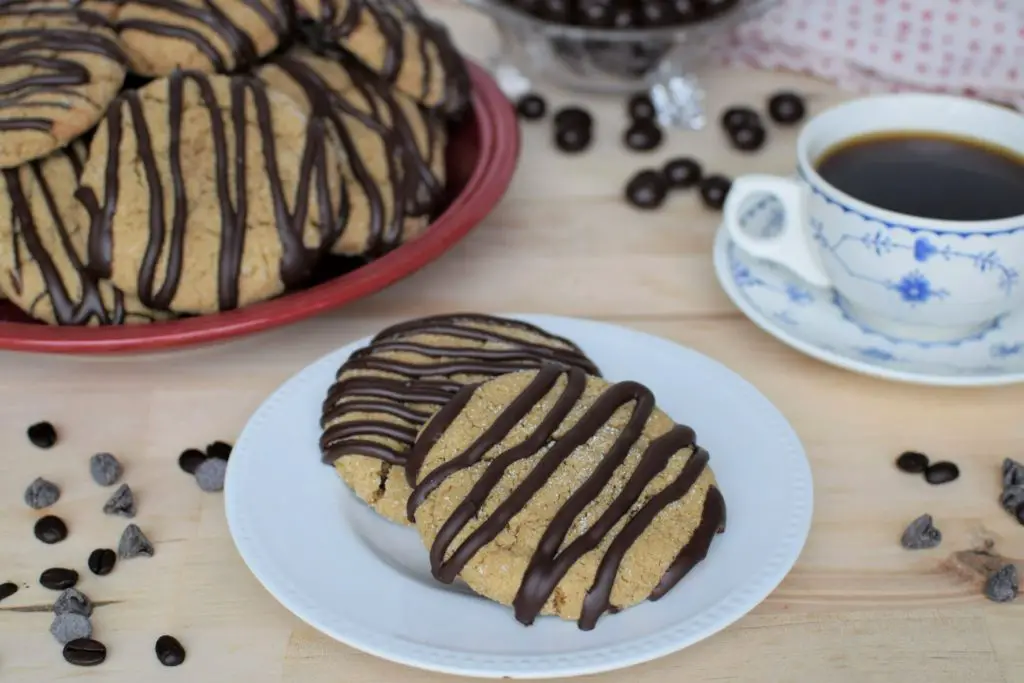 Coffee and coffee cookies on a plate with chocolate drizzle