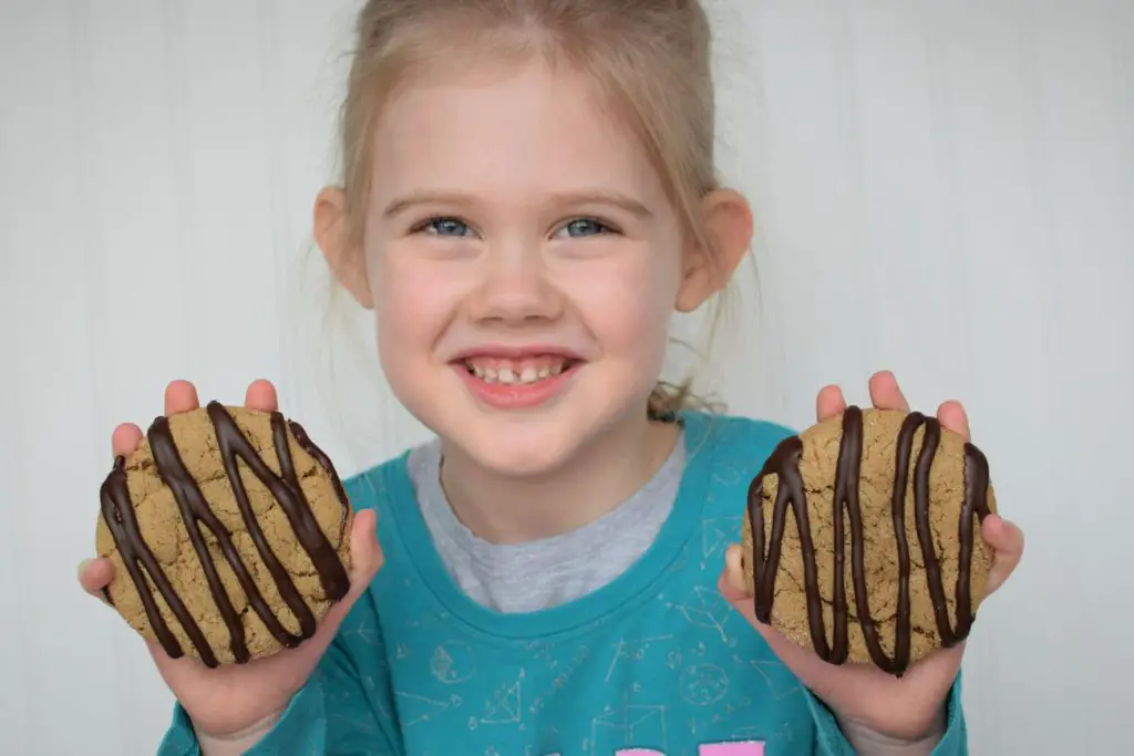 Girl holding two coffee cookies