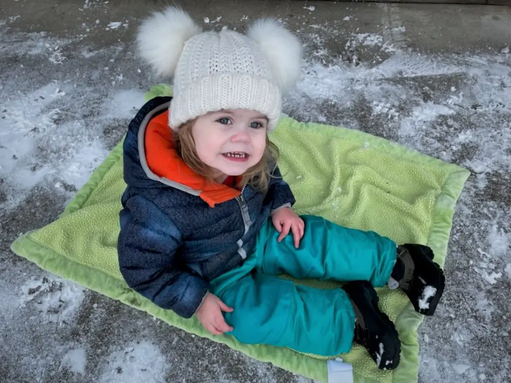 Ellie sitting on blanket in the snow
