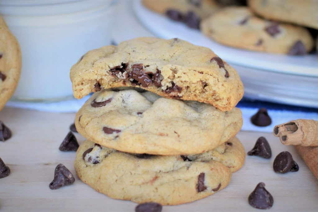 Stack of cinnamon chocolate chip cookies, top one bite out of - this bread will rise