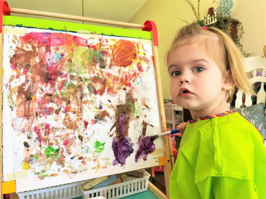 girl painting in a greed smock - this bread will rise