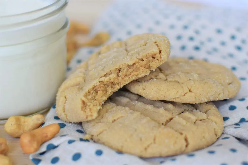 Cashew butter cookies on a cloth napkin next to a glass of milk - this bread will rise