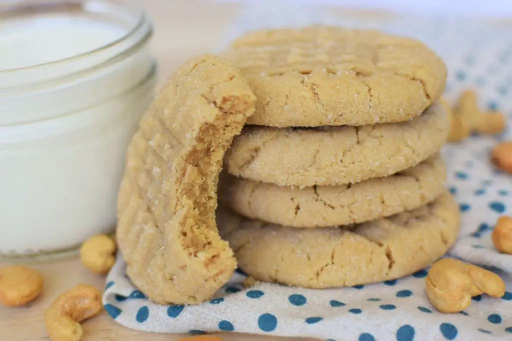 Cashew butter cookies on a napkin next to a glass of milk - this bread will rise