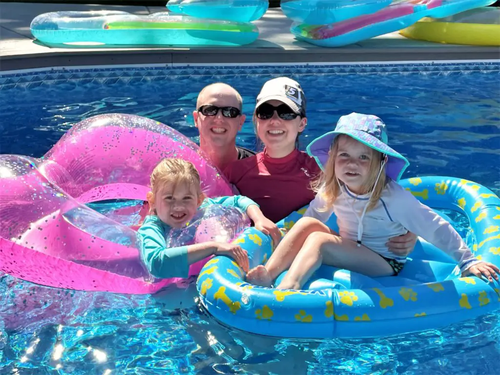 family picture in pool with two girls on floaties - this bread will rise