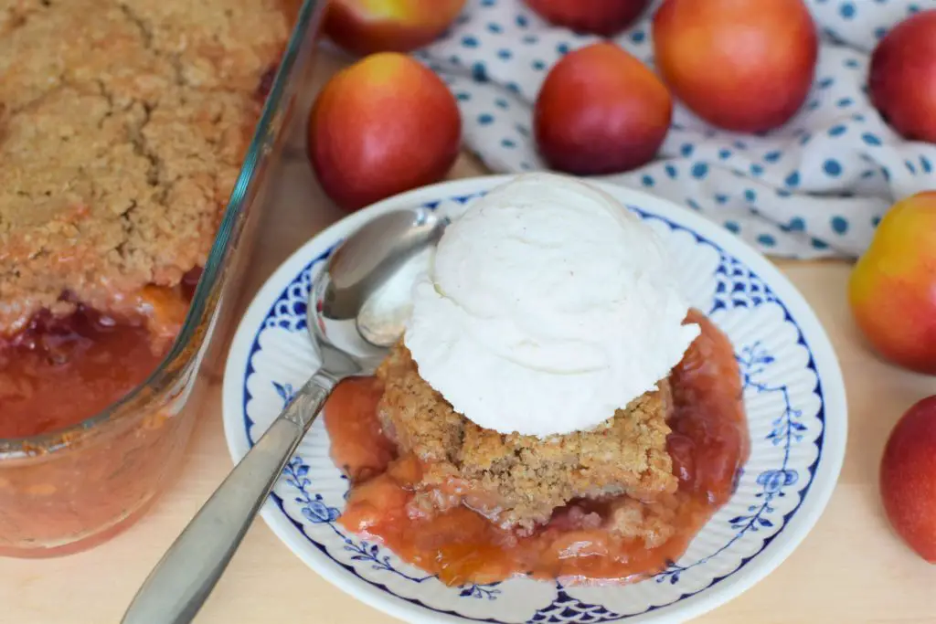 Dish of plum cobbler with ice cream on top.