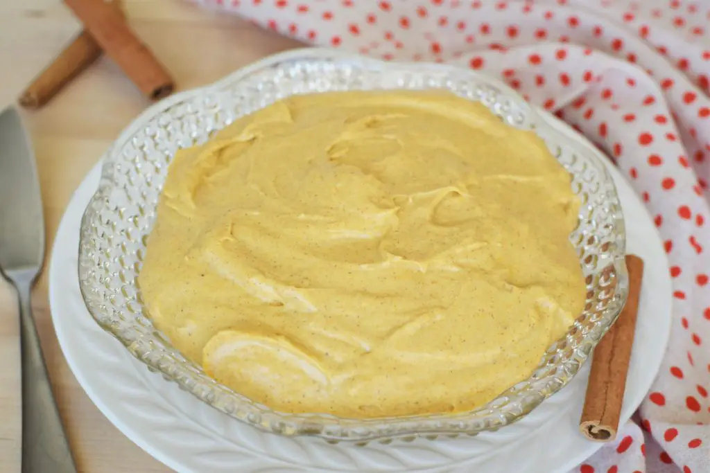 Pumpkin cream cheese in a bowl with a spreader on the table next to it - this bread will rise