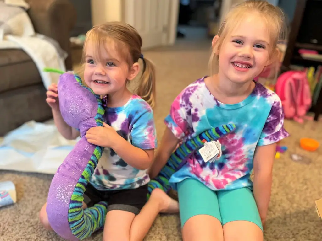 Two young sisters holding plush snake - this bread will rise