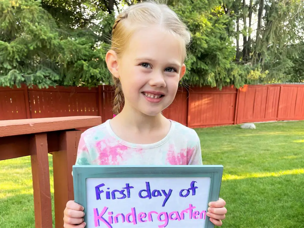 Girl holding first day of kindergarten sign - this bread will rise