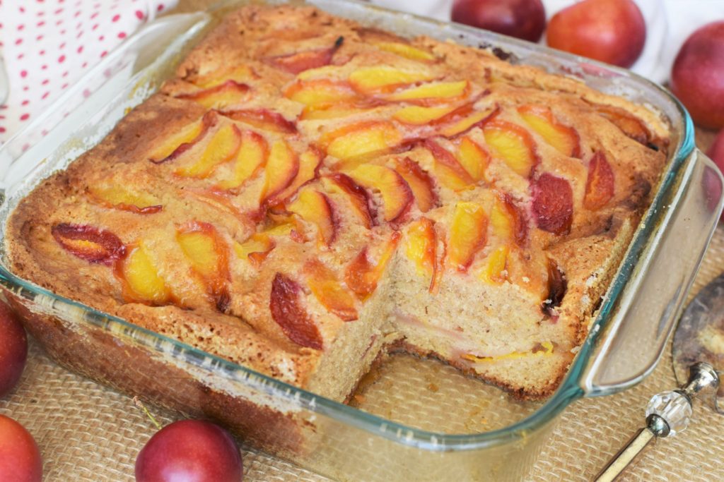 Square spiced plum cake with piece taken out. This bread will rise