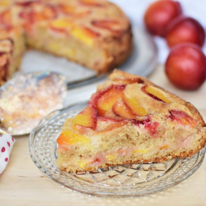 Slice of plum cake sitting in front of plum cake - this bread will rise