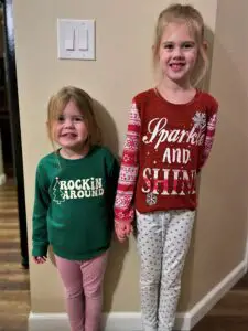Two girls with Christmas shirts.