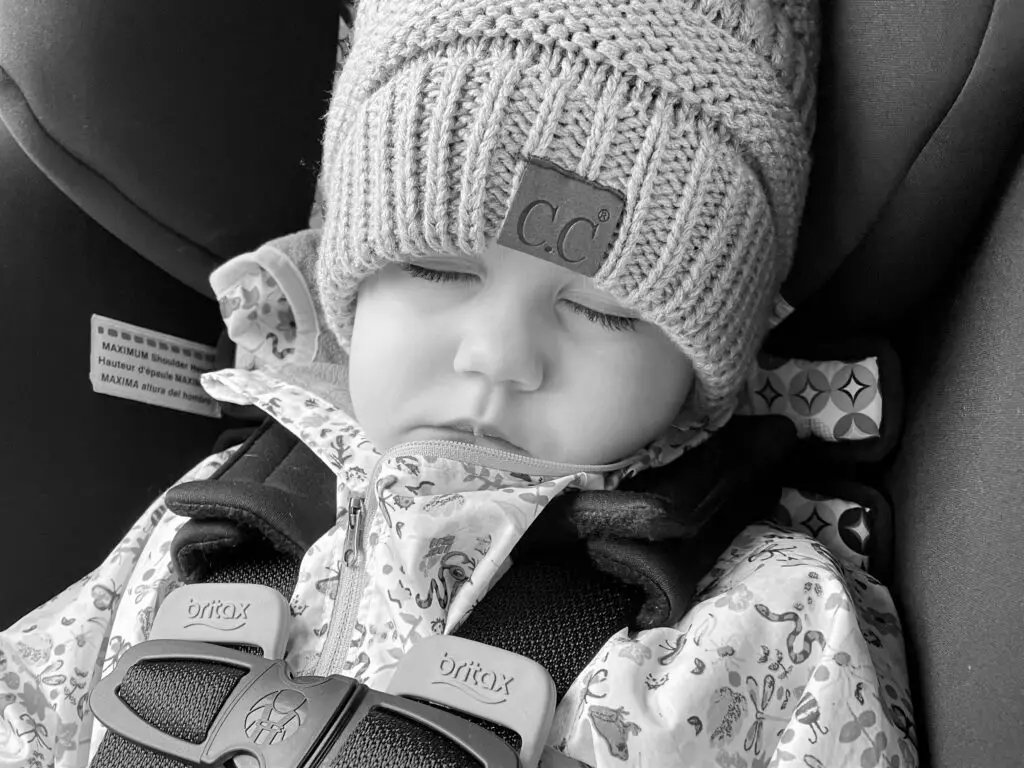 Young girl sleeping in carseat.