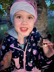 Girl eating smore at night with messy face.