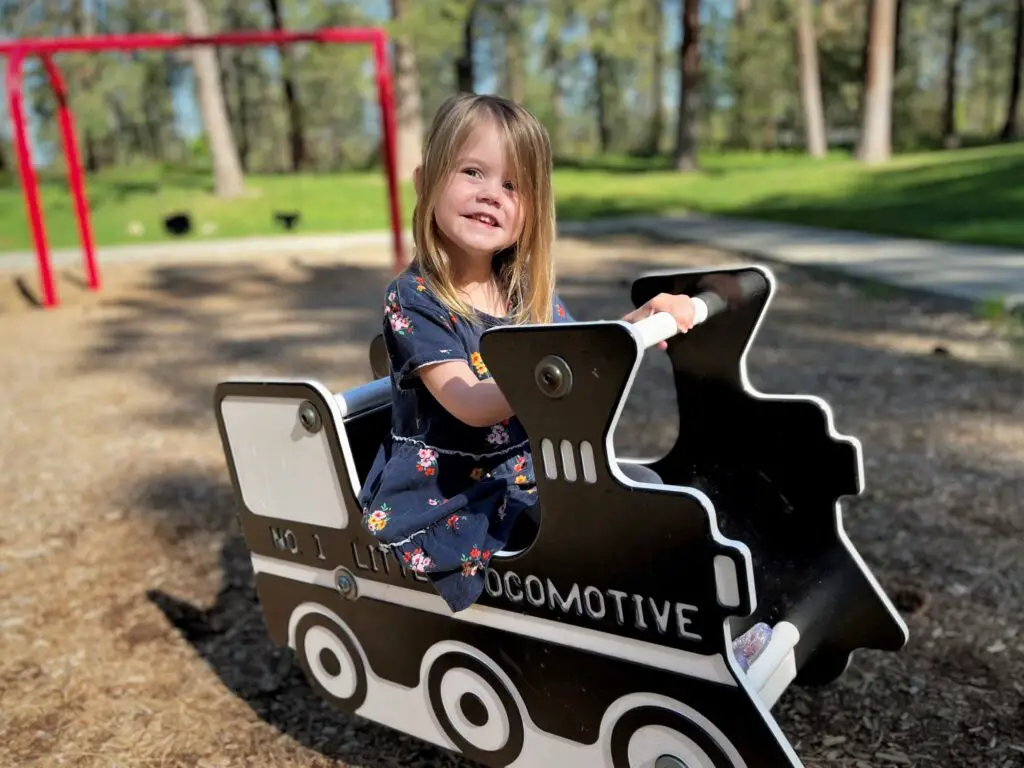 Ellie playing in a train at a park -this bread will rise