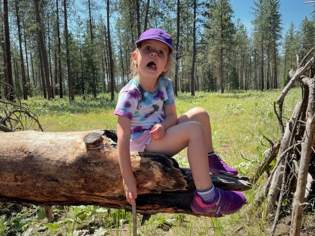 Girl sitting on a log making a face - this bread will rise