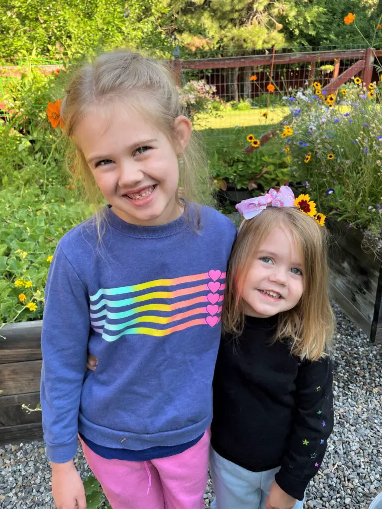 Rosie and Ellie posing with flowers in their hair.