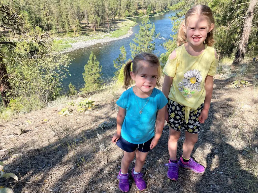 Rosie and Ellie standing next to a river on a sunny day.