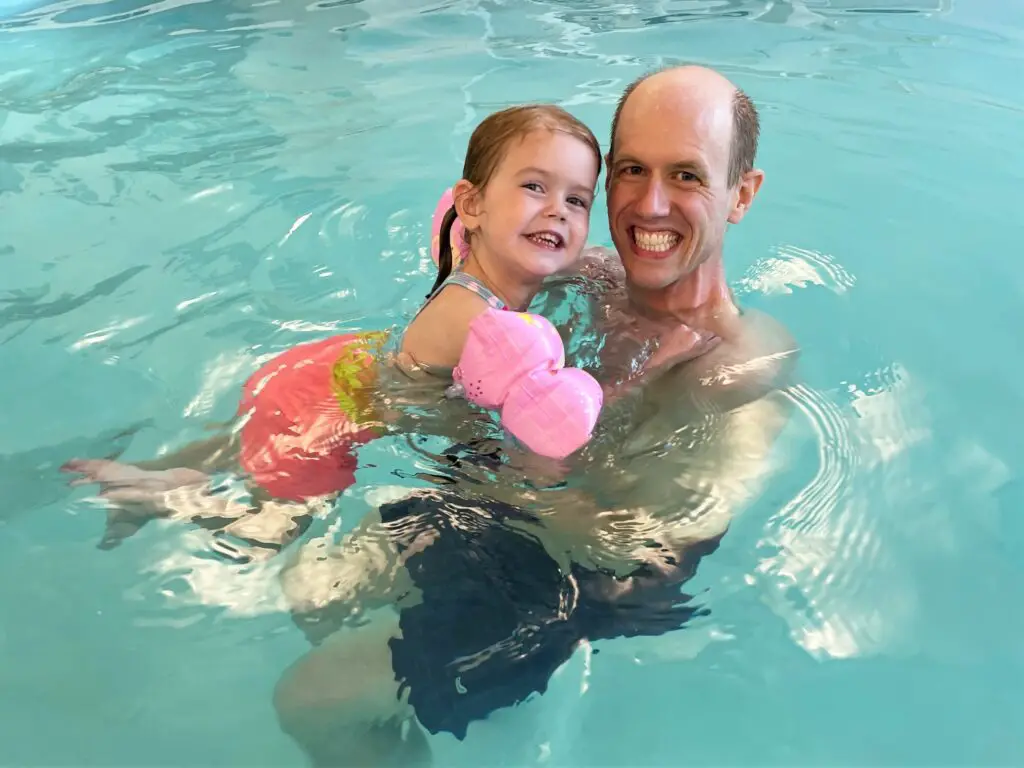 Ellie and her dad swimming in the pool.