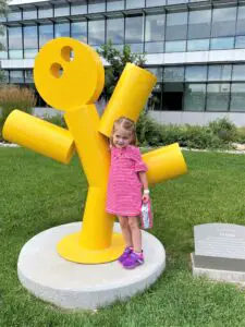 Ellie next to a sculpture of a yellow dancing man