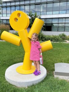 Ellie next to a sculpture of a yellow dancing man