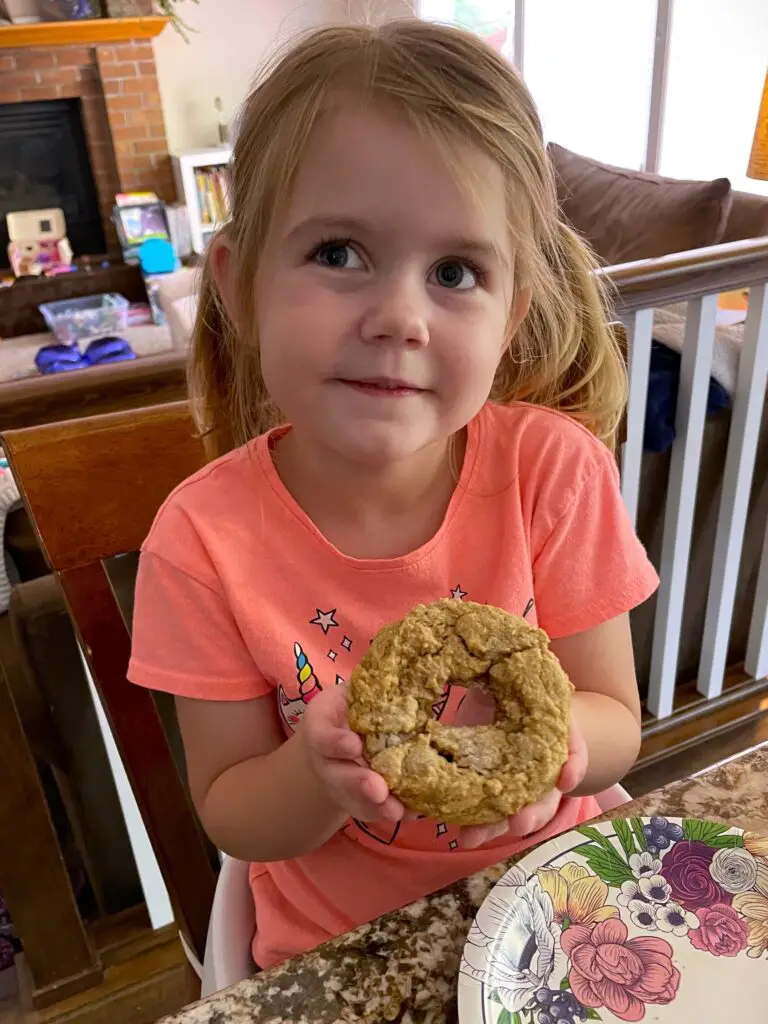 Ellie holding an almond flour donut - this bread will rise