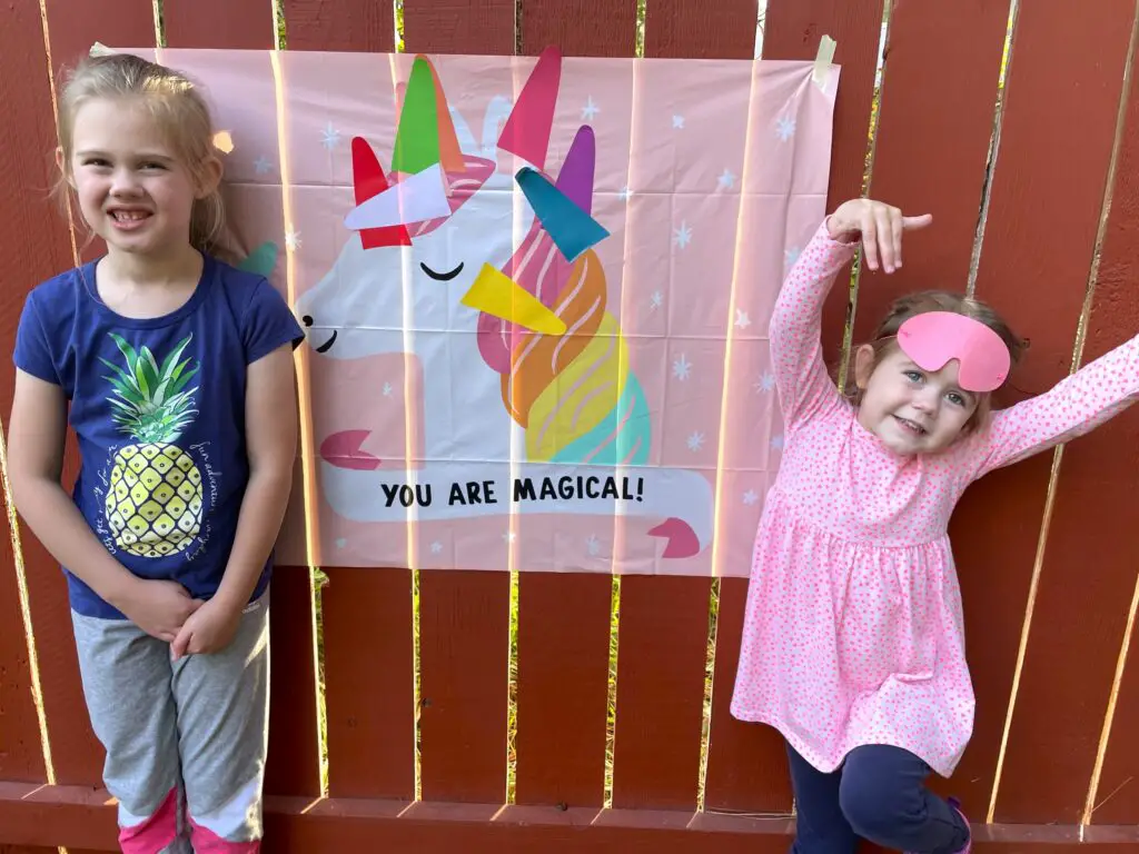 Sisters playing pin the horn on the unicorn